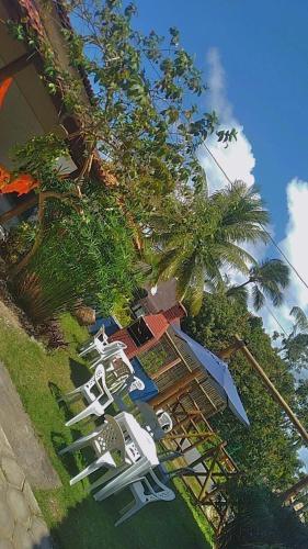 a group of lawn chairs and umbrellas on the grass at Pousada Pôr do Sol in Barra Grande