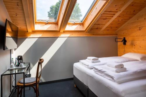 2 Betten in einem Dachzimmer mit Fenster in der Unterkunft Dom Gościnny Maximus in Lubomierz