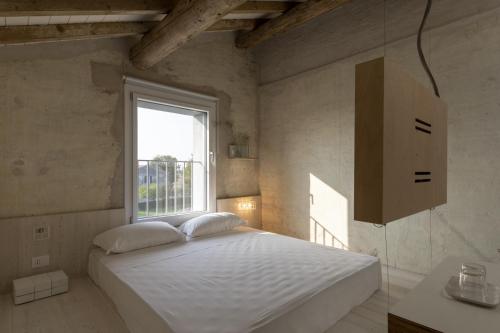 a bedroom with a white bed and a window at La Pervinca - Ospitalità, Natura, Cura in Guastalla