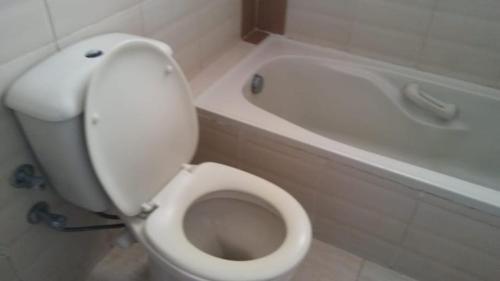 een badkamer met een wit toilet en een bad bij شاليه مرقيا بالساحل الشمالي صف اول بحر in Dawwār ‘Abd al Qādir Qāsim