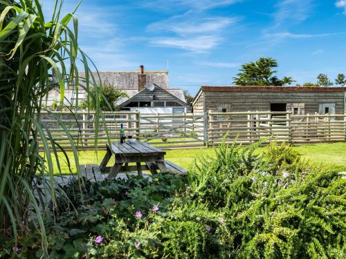 a wooden fence and a picnic table in a garden at Atlantic Lodge in Port Isaac