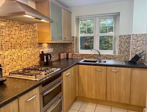 een keuken met houten kasten en een fornuis met oven bij Private Luxury Room Southampton in Southampton