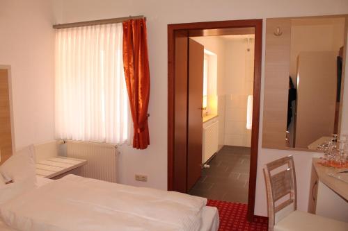 a bedroom with a bed and a window and a mirror at Hotel Fürsteneck in Bernburg