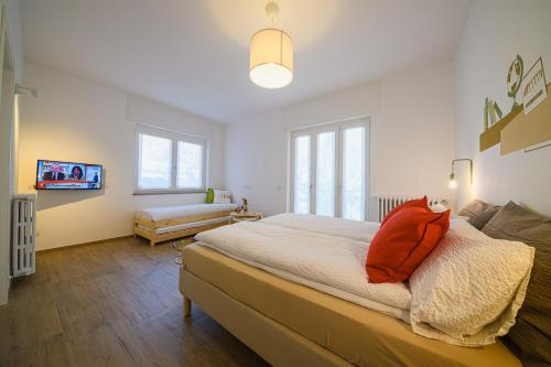 Schlafzimmer mit einem großen Bett und einem roten Kissen in der Unterkunft Alessia' s Home in Tirano