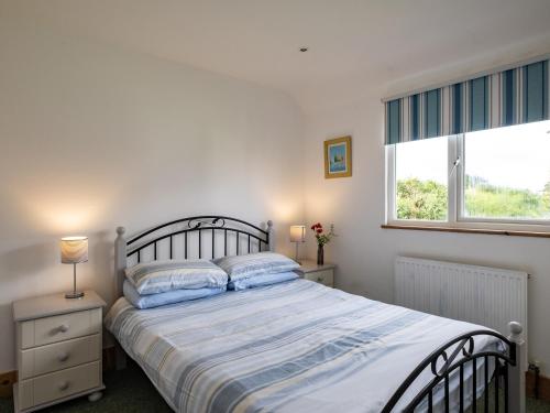 a bedroom with a large bed and a window at Gull Lodge in Port Isaac