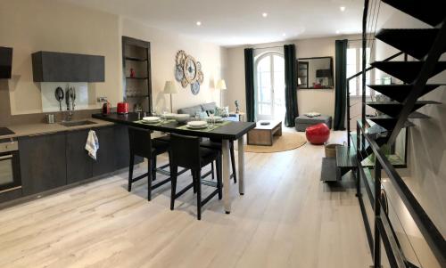 Il dispose d'une cuisine et d'un salon avec une table et des chaises noires. dans l'établissement Le Loft sur les quais, à LʼIsle-sur-la-Sorgue