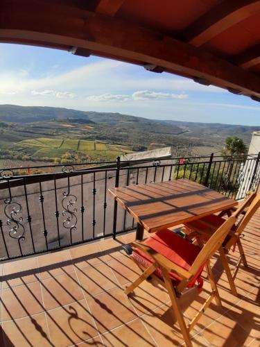 a wooden table and chair on a balcony with a view at Guesthouse Villa Marija in Motovun