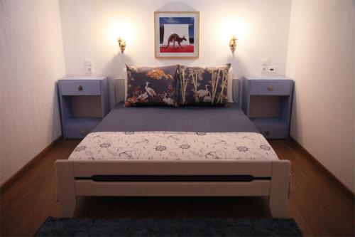 1 dormitorio con 1 cama con 2 mesitas de noche en Stone Mansion House en Skopelos Town