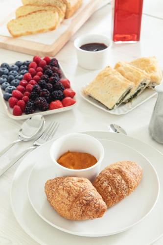 a white plate with pastries and fruit on a table at La Pervinca - Ospitalità, Natura, Cura in Guastalla