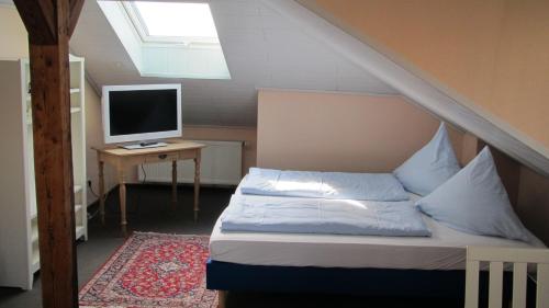 a bedroom with a bed and a desk with a computer monitor at Hotel AlleeSchlößchen in Bad Wildungen