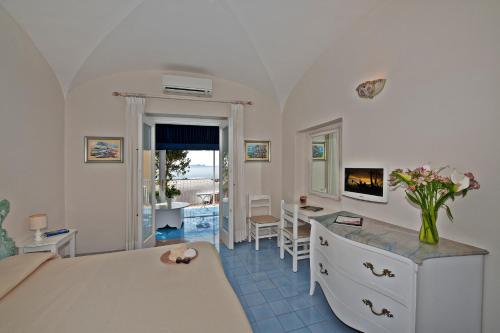 a bedroom with a bed and a desk and a table at Villa La Tartana in Positano