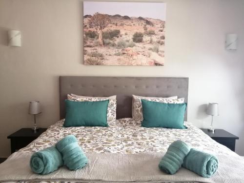 a bedroom with a bed with two blue pillows at Ikamu's lodge in Germiston