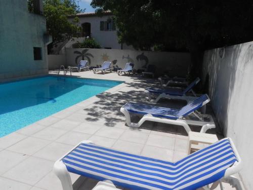 two blue and white chairs and a swimming pool at Motel Cap Sol in Mandelieu-la-Napoule