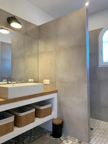 een badkamer met een wastafel en een spiegel bij Le Petit Bali Spacieuse Villa pour 8 avec Piscine in Saint Cyprien Plage