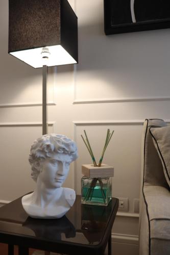 a bust on a table next to a lamp at Calzaiuoli3 Luxury Flat in the City Center of Florence in Florence