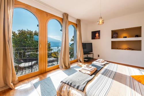 a bedroom with a bed and a large window at CASA LUNA ALMA in Brione sopra Minusio