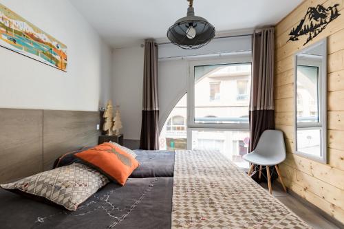 une chambre avec un lit et une grande fenêtre dans l'établissement APPARTEMENT CENTRE VILLE WIFI PARKING DRAPS FOURNIS, à Cauterets