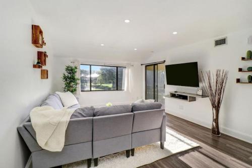 a living room with a couch and a flat screen tv at Saddlebrook Gem private condo with Kitchen in Wesley Chapel