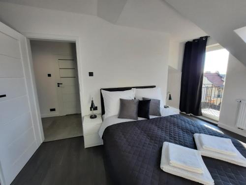- une chambre avec un lit et 2 serviettes dans l'établissement Cracow by Night Apartments, à Cracovie