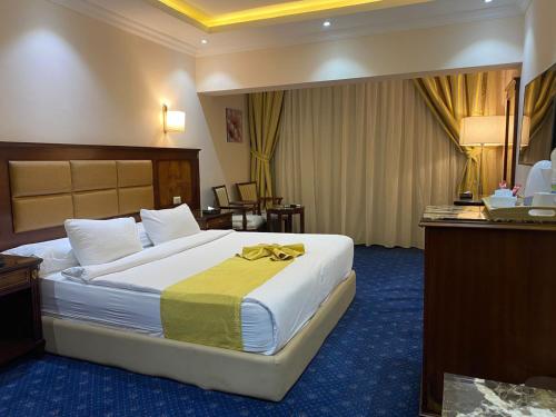 カイロにあるMoon Light Hotel Cairo DAR EL ESHARAの黄色い毛布が付いたベッドが備わるホテルルームです。