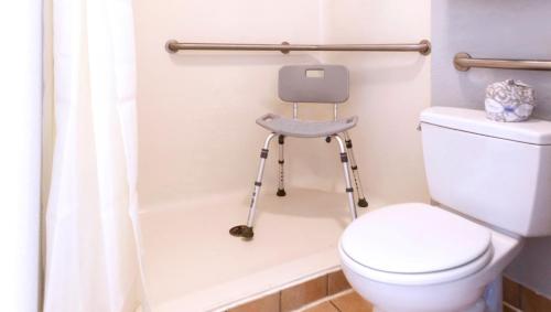 a bathroom with a stool next to a toilet at Sunrise Inn Williamstown in Williamstown