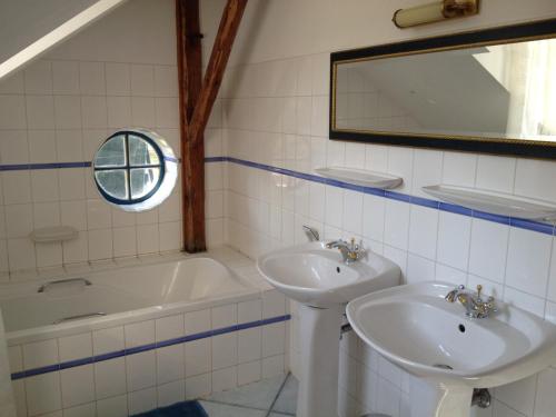 a bathroom with two sinks and a tub and a mirror at B&B U Kaplicky in Všelibice