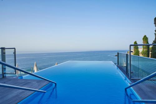 a swimming pool with the ocean in the background at Hotel Balcón de Europa in Nerja
