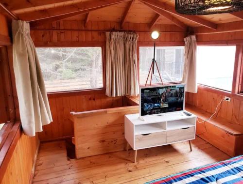 un soggiorno con TV in una cabina di Cabaña Isla Negra a Isla Negra