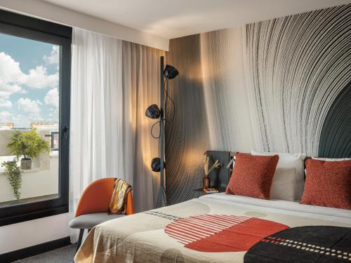 a hotel room with a bed and a window at Novotel Paris Vaugirard Montparnasse in Paris
