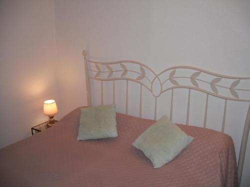 une chambre avec un lit avec deux oreillers dessus dans l'établissement Les Emeraudes, à La Croix-Valmer
