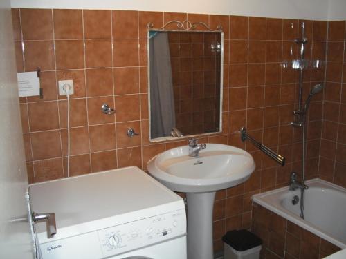 une salle de bain avec un lavabo, un miroir et une baignoire dans l'établissement Les Emeraudes, à La Croix-Valmer