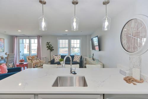 a kitchen with a sink and a large clock on the wall at Harbourtown Suites on Plymouth Harbor in Plymouth