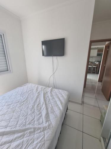 sypialnia z łóżkiem i telewizorem z płaskim ekranem w obiekcie Apartamento Novinho Próximo as Praias, Centro e Restaurantes - Excelente localização w mieście Ubatuba