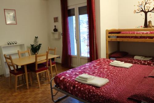 a bedroom with a bed and a table and a dining room at B&B Taramelli in Trento