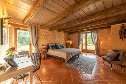 a bedroom with a bed and a table and chairs at L'Oree du ciel in Cordes-sur-Ciel