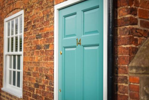 a blue door on a brick building with a window at Fourteen westgate in Louth