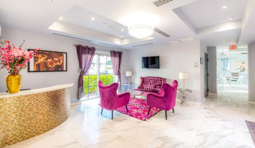 a living room with pink chairs and a table at Secret Garden Miami Beach in Miami Beach