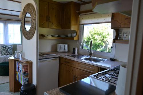 a small kitchen with a sink and a window at Swallows Return in Clynderwen
