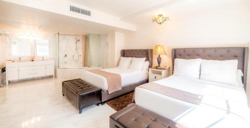a hotel room with two beds and a bathroom at Secret Garden Miami Beach in Miami Beach