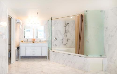 a bathroom with a shower and a sink and a tub at Secret Garden Miami Beach in Miami Beach