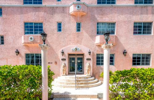 a red brick building with a door and stairs at Secret Garden Miami Beach in Miami Beach