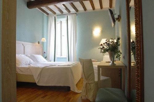 ein Schlafzimmer mit einem weißen Bett und einem Fenster in der Unterkunft Albergo Morandi in Reggio nell'Emilia