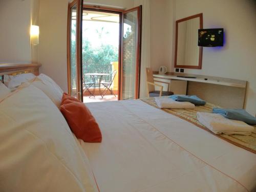 a bedroom with a large white bed with a desk at Hotel Residence Piccolo in Parghelia