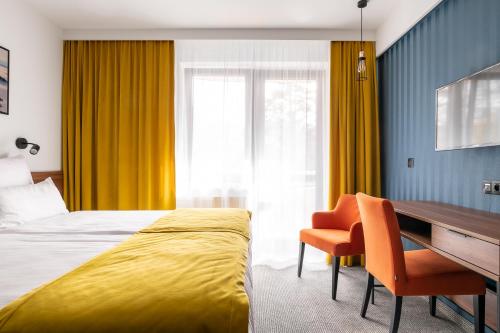 a hotel room with a bed and a desk and a desk at Hotel Vestina in Wisła