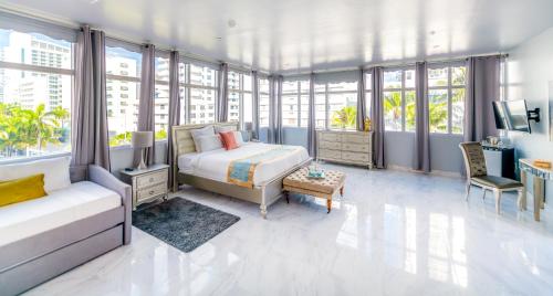 a bedroom with a bed and a room with windows at Secret Garden Miami Beach in Miami Beach