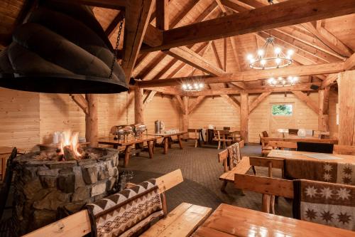 a dining room with wooden tables and a fireplace at Hotel Vestina in Wisła