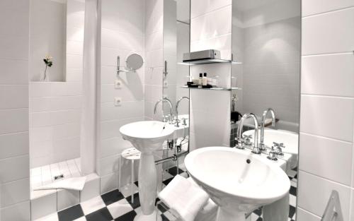 a white bathroom with two sinks and a tub at Privathotel Lindtner Hamburg in Hamburg