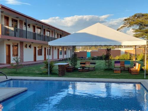 a swimming pool in front of a house with a tent at Quinta San Felipe in Tababela