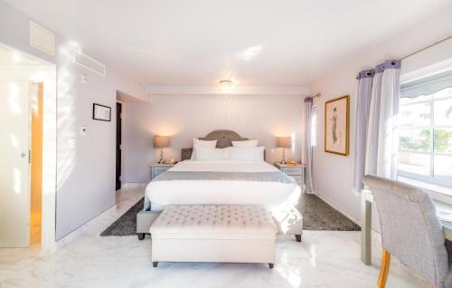 a white bedroom with a bed and a window at Secret Garden Miami Beach in Miami Beach