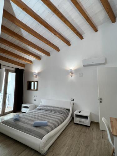una camera con un grande letto in una stanza con soffitti in legno di L’ANGELO BIANCO a Pula